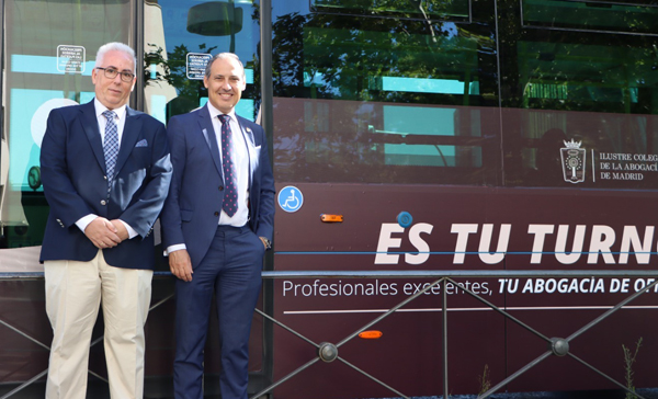 Eugenio Ribón y Juan Manuel Mayllo junto a uno de los autobuses de la campaña del ICAM con motivo del Día de la Justicia Gratuita en julio de 2024